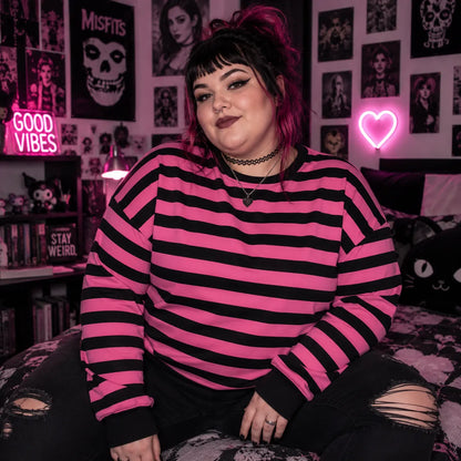 Alternative fashion model wearing a pink black striped crewneck sweatshirt