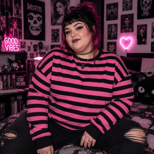Alternative fashion model wearing a pink black striped crewneck sweatshirt